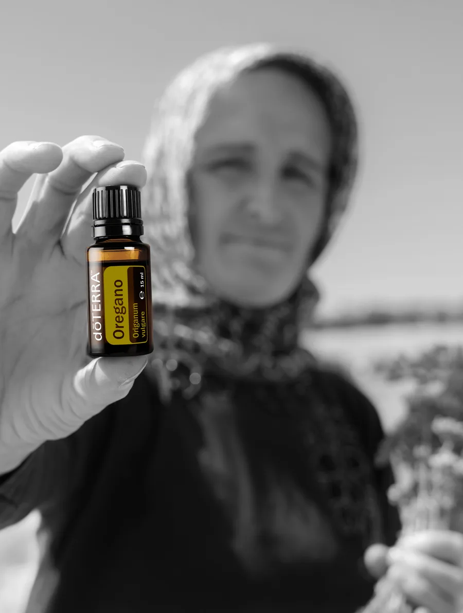 Frau hält eine Flasche dōTERRA Oregano-Öl in die Kamera