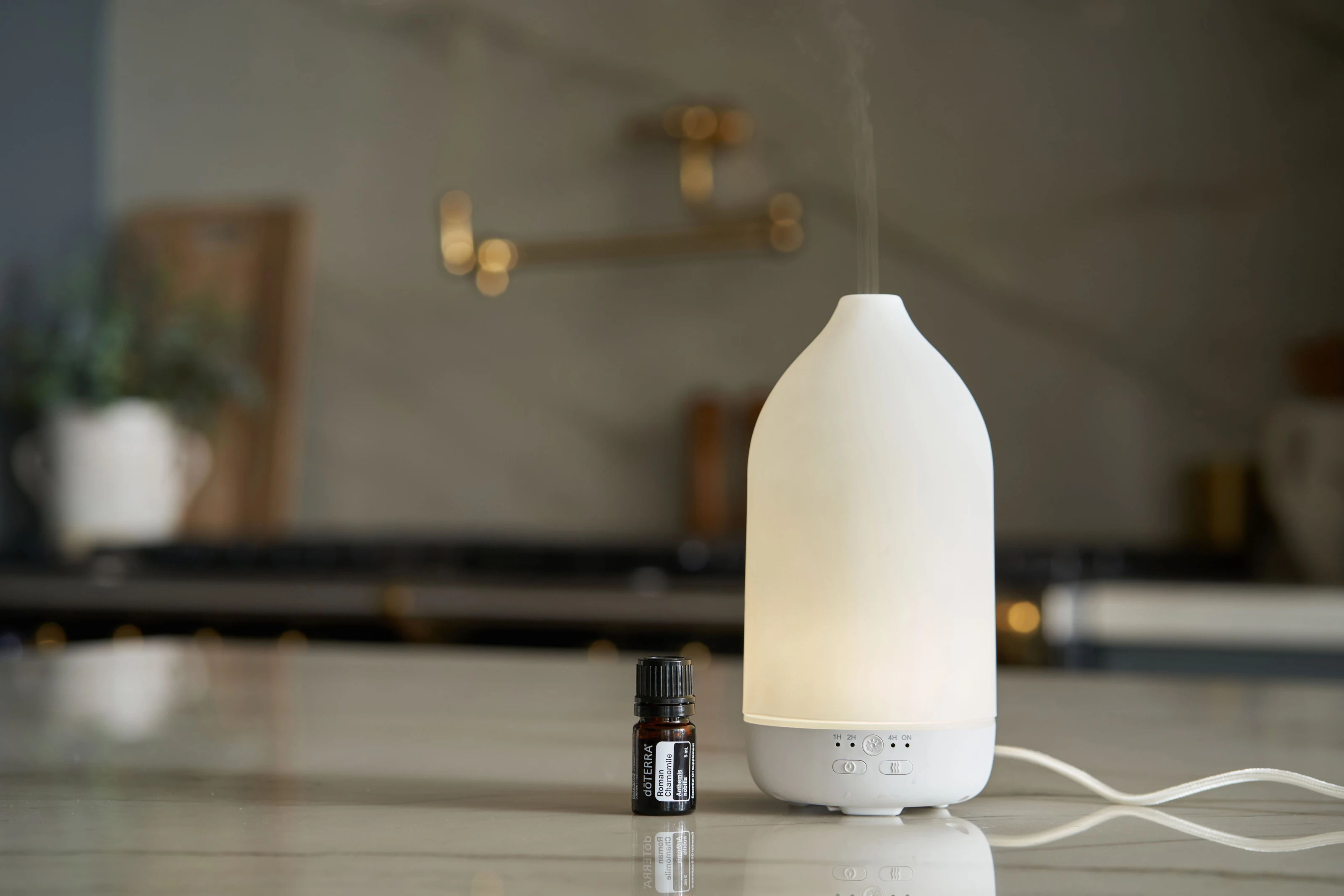 Leuchtender Diffuser mit einem Fläschchen ätherischem Öl daneben